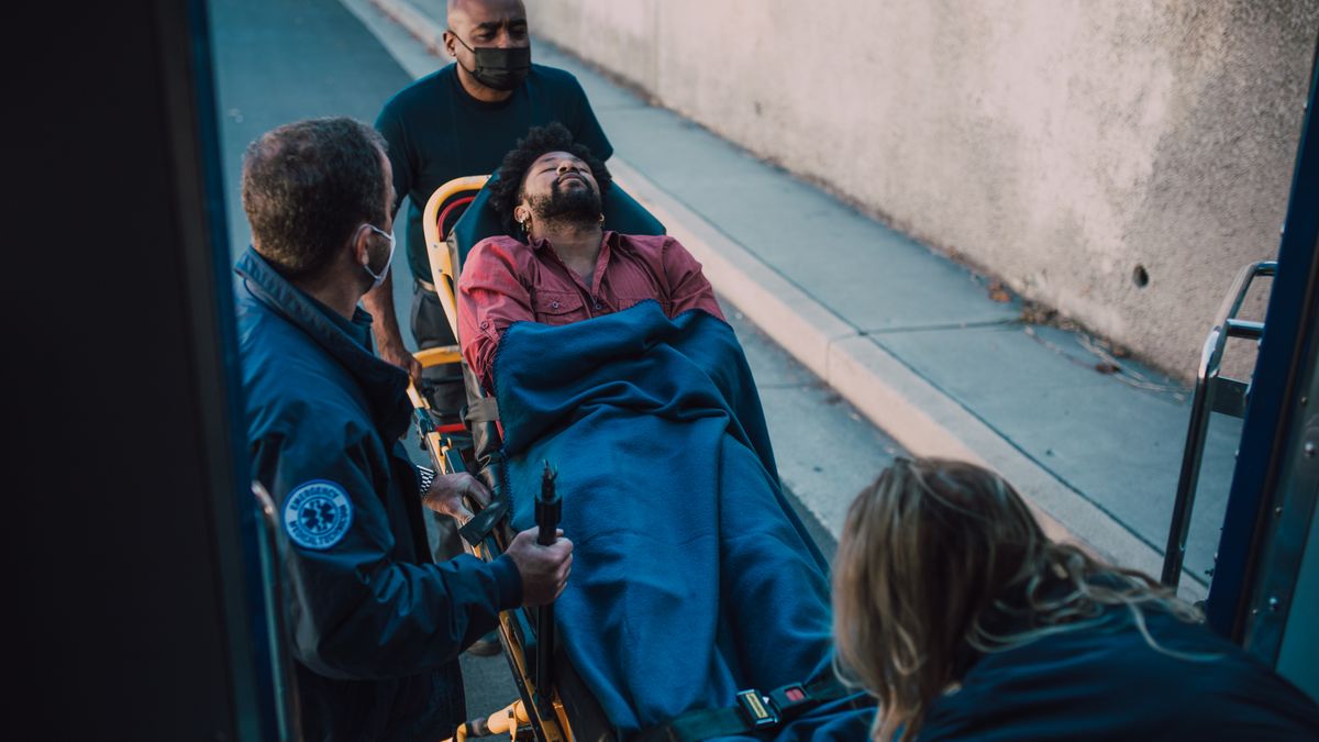 Paramedics moving a patient on a stretcher during an emergency cardiac response