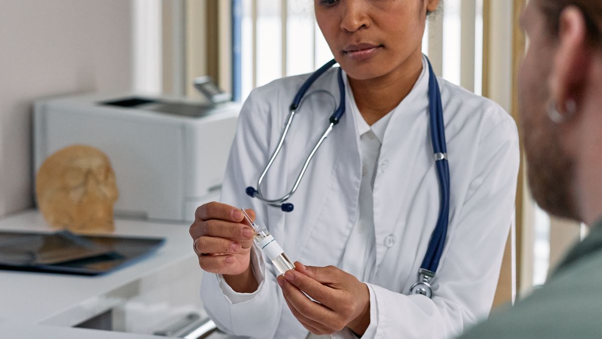 Doctor reviewing medication and recovery progress with a patient during a post-dengue follow-up consultation