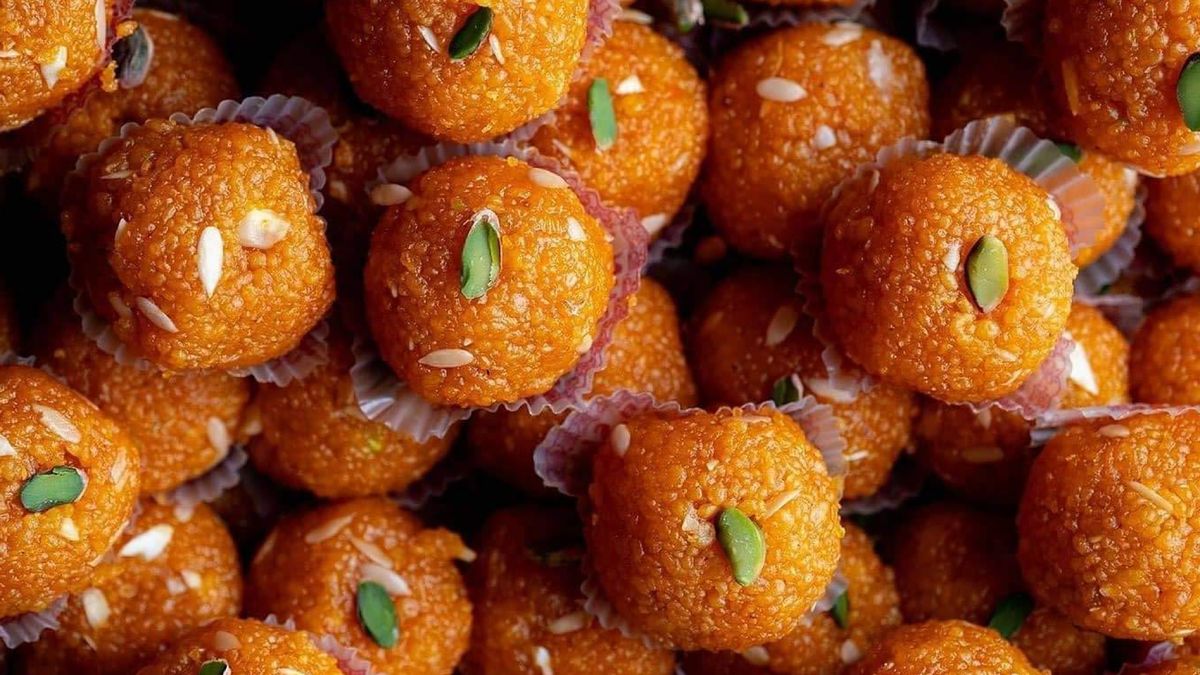 Indian laddoos topped with almonds and pistachios, illustrating portion size for festive sweets