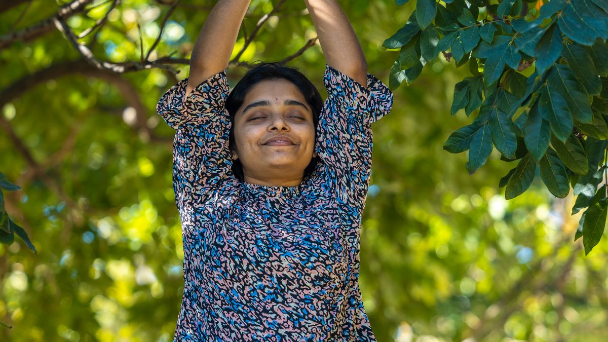 Woman meditating outdoors to manage stress
