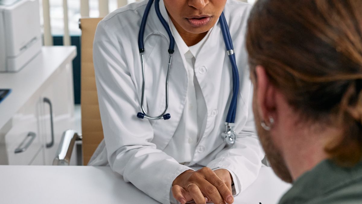 Doctor discussing a health chart with a patient during a consultation about bone density screening
