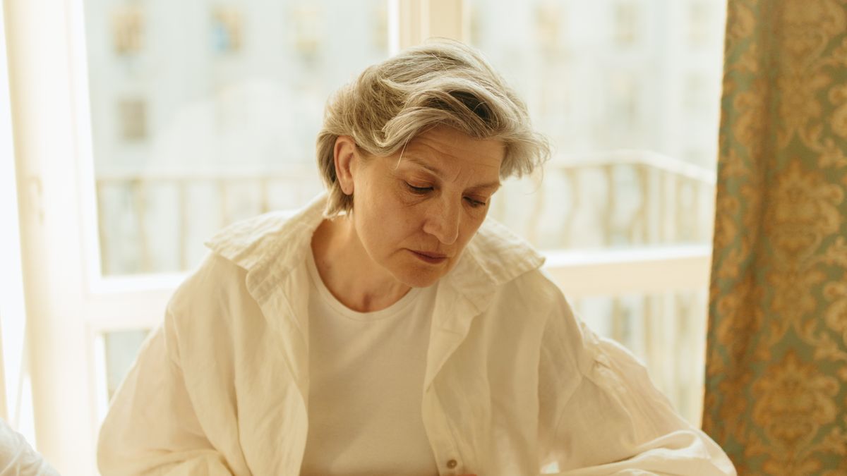 Senior woman checking her blood pressure at home with a digital monitor during the festive season